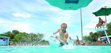 Kyle Frey, 16, falls into the pool backwards using the deep end's slide at the Bloomsburg Town Park Pool Sunday afternoon. The park was full of people cooling off from the soaring temperatures.