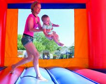 Megan Wark, Berwick, swings her daughter, Lillie, 1, through the air in a bounce house at the West Berwick Fire Company Carnival Friday evening.