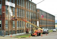 A crew with Donald E. Kocher, Inc., of Orangeville, repoints the brickwork on the Autoneum building along West Fifth St. in Bloomsburg on Tuesday. The date on the cornerstone of the former Magee Carpet building is 1908.