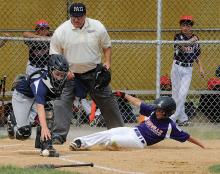 Berwick catcher Blake Maurer, left, reaches for the ball after dropping the throw on a force play at home plate as Danville’s Charlie Betz scores in the bottom of the third inning during Sunday afternoon’s minor division game at the East Snyder Park near Selinsgrove. Danville would go on to win, 9-2.