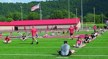 Press Enterprise/Zach Pippen Wednesday evening varsity players stretch and warm up with the young campers at the 2nd Annual Stacy T. Frye Youth Football Camp held at Bloomsburg High School Football Field.