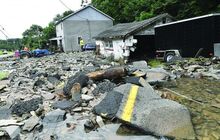 Rocks, wood and chunks of pavement fill the yard at 171 Foundryville Road in Briar Creek Township Tuesday after flood waters washed the debris onto the property. The water also took out a wall of the garage.