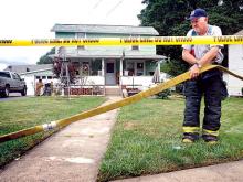 Berwick Fire Capt. Howard Lutz sets up a hose as firefighters prepare to stand by while police search and remove suspected methamphetamine-making ingredients from the house at 137 Summerhill Ave. in Berwwick on Wednesday afternoon. Earlier, Brian McLellan, 44, and Stanley Lunger, 37, were taken into custody at the house. 