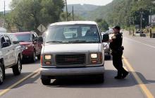 Danville police officer Keith Davenport talks to a driver in the center turn lane near the entrance of the Danville Middle School on Route 11 Monday afternoon. 