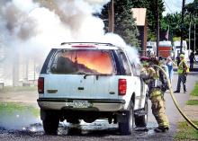 Burning magnesium explodes, sending sparks from a Ford Expedition, as Espy firefighters spray water on the SUV on Snyder Ave., just off Tenny Street in Espy shortly before noon on Thursday. 