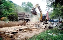 A demolition crew from G.M. Crawford loads the rubble from the former home of Pat Parker at 558 Drinker Street in Fernville on Monday. This is the first of approximately 20 houses to be demolished in Fernville as part of a flood buyout program. 