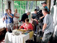 Geisinger Gold member Gail Hetzendorf, seated, of Turbotville works with beads as a crew from Curt Crane Productions sets up to film her on a sun porch of a house along Old Berwick Road in Scott Township on Monday morning. Hetzendorf is one of 17 Geisinger Gold members to be appearing in two 60-second TV commercials and one five-minute video for the health plan for seniors. 