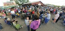 People crowd in around the Pavilion on the Montour-DeLong Community Fairgrounds to listen to Aaron Kelly perform Wednesday evening. 