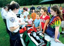 Danville Ambulance member Nancy Race, left, talks with, from right: Anna Tessarvich, Leah Tessarvich, Charlie Cicero, Sarah Ciero and Sage Gettis at the National Night Out, Tuesday at the Washies Playground. National Night Out is a community police, fire and rescue event held the first Tuesday of August since 1984. The event is meant to increase awareness about police programs in communities, such as drug prevention, town watch, neighborhood watch, and other anti-crime efforts.