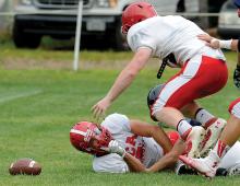 Mount Carmel’s Tyler Thompson, bottom, knocks the fumble out of the reach of Blue Mountain’s quarterback, Sean Greenawalt, background right, before Mount Carmel’s Wesley Shurock would jump on it to recover during Friday night’s scrimmage at Lourdes.