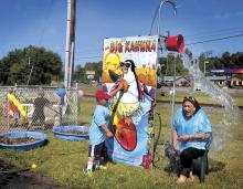 After missing his three tosses with wet sponge balls, Landen Hoffman, 6, steps up and hits the release button with his hand to send a bucket of cold water on Maggie Urquhart, owner of Wee Little Angels Child Care in Lime Ridge on Thursday morning.