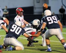 Berwick's Ray Grasley, left, and Will Updegrove, center, hit Selinsgrove's Angelo Martin, second from left, forcing the fumble that was picked off by Berwick's A.J. Vandermark and taking it back for a 10-yard touchdown during the first quarter of Friday night's game in Berwick. 