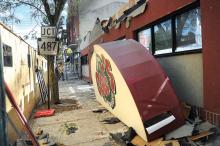 Workers from Sokol Excavating, Paving and Demolition remove part of the facade to expose the steel beams on the front of the former Cole's Hardware store Wednesday morning.