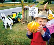 Blake “Dewey” Rothermel. 2, displays one of the gourds he’s selling from his roadside stand in front of his grandparents’ Dottie and Skip Rothermel’s butchering business along Rushtown Road outside of Riverside on Monday.
