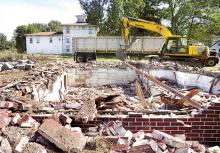 An excavator from demolition contractor Penn Earthworks loads debris from the remains of a brick house last owned by Jon and Michele Benfield at 2827 Old Berwick Road in Scott Township on Thursday. 