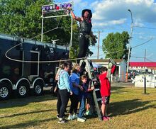 Andy Rotz swings his lasso around a growing crowd during his Wild West Extravaganza near the Barton House on Bloomsburg Fairgrounds on Friday.