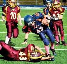 Mason’s Monogramming Bears’ Ben Knorr is tripped by a Locker Room Redskins defender during a Berwick Youth Football League B division game at Crispin Field on Sunday. 