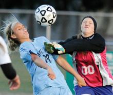 Millville's Maci Bower, left, heads the ball from over the hands of South Williamsport goalkeeper Kelsey Gantz and into the net to score Millville's second goal of the game with just over 30 seconds to play in the first half of Tuesday afternoon's district playoff game at Central Columbia. 
