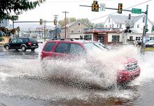 An SUV splashes through standing water while turning onto East Street from Columbia Blvd. in Bloomsburg during the heavy rain on Monday. 