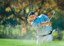 Central Columbia's Josh Levitski powers out of the green side bunker on hole 12 at Golden Oaks Golf Club in Fleetwood Tuesday morning. Levitski chipped the ball onto the green during the PIAA East Regional Golf Championships.
