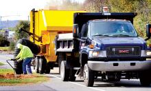 Scott Township worker Brian Houser vacuums leaves left along the side of the road on Lackawanna Ave. during collection on Tuesday afternoon.