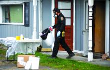 A member of the State Police clandestine lab team removes suspected meth making materials out of a home along Second Street in Lime Ridge Friday afternoon.