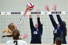 Delaware Valley’s Katharine Quinn, left, puts the ball just over the next into Berwick’s Julia Troiani, center, and Isabella Varvaglione during the first set of Thursday evening’s match at Berwick. 