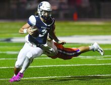 Berwick’s quarterback Ethan Lear pull free from the hands of Danville’s Lincoln Diehl and picks up 2-yards during the second quarter of Friday night’s game at Berwick.