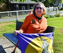 Janice Longenberger sits with one of the banners which hang on the utility poles along the parade route in Catawissa. 