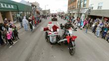 Mike Laubach chauffeurs Santa Clause along in his motorcycle sidecar as they head along West Front Street in Berwick Friday morning at the end of the borough's annual Santa parade. 