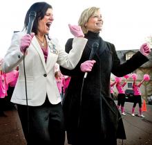 Susan Hallick, left, Geisinger’s executive vice president and chief nursing officer, and Sue MacInnes, Medline’s chief marketing officer, dance together in front of the Pine Barn Inn during Friday's announcement that Geisinger Health System is the winner of Medline’s third-annual national Pink Glove Dance video competition.