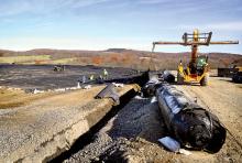 Workers install a liner that will be under the soccer fields at the East Branch Recreation Area along Route 44 in Madison Township on Monday morning. The PPL project will help stop a substance that is leaching out of the StabilFil fly ash under the fields. 
