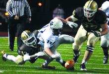 Berwick's Andrew Force, center, falls on a fumbled ball against Bethlehem Catholic's Josh Heron, left and Paul Mancini Friday in Allentown.