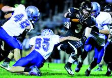 Southern's Nate Hunter, center, runs past a tackle by Warrior Run's Jake Rohm Friday at Southern.
