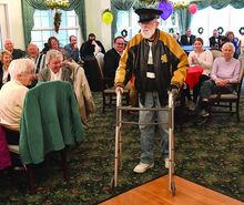 Joe Drane walks through the room with over 75 people cheering for him during a 100th birthday party surprise for Drane Wednesday afternoon at the Meadows Community Center in Mahoning Township