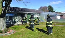 Press Enterprise/Jimmy May Reliance firefighters use a hose line to vent smoke out a front window at a home at 173 Park Blvd. in Park Place Village Tuesday after knocking down a fire. 