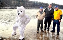 Ryann Cymbala, dressed in polar bear attire, tests the chilly waters of the Susquehanna River from the launch at the Catawissa Boat Club on Friday. Standing with her are Catawissa Valley Lions Club members, from left, Paul Sevison, president; Craig Long, secretary; and Dale Kreischer, treasurer. 