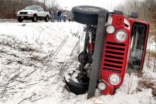 A 1997 Jeep Wrangler lies on its side in a ditch along Route 11 after driver Kathy Berns, 51, of Bloomsburg, lost control on a patch of black ice in the northbound lane in Montour Township on Tuesday afternoon. 