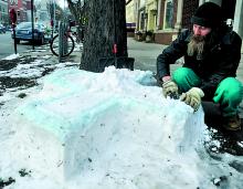 Greg Badger, Bloomsburg, works to fill footprints in his latest snow creation outside the Bloomsburg Library Friday afternoon. 