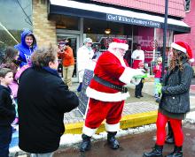Santa and his elves hand out candy canes to families lined up on Mill Street after is arriving in Danville for the holiday season. Santa's cottage, located between the borough municipal building and Beiter's Department store, will be open from 5 p.m. to 7 p.m. Fridays and noon until 3 p.m. on Saturdays through Dec. 21.