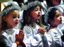 St. Cyril Academy students, from left, Teagan Shroyer, Emma Houston and Nora Mauro sing in a choir of angels during the preschool and kindergarten’s Christmas Pageant in the Basilica of SS. Cyril & Methodius in Danville on Sunday afternoon. 