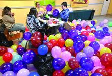 Children Museum members, from left, Josie Weibel, Ellen Mika, Sara Mika, manager and Roman Peterson use different methods while inflating balloons Monday in preparation for the museum’s count down to noon on Tuesday. They plan on filling 1,000 balloons for the event. 