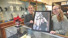 Alexa Bowman-Klees, left, holds up a photo of her father, the late Bruce Bowman Jr., with Bella Tarantino inside Sneidman’s Jewelry Store on Thursday afternoon in Bloomsburg.
