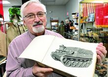 Tom McLaughlin, curator of the Stuart Tank Museum, holds a book which shows the M37 Tank Destroyer while at the Berwick museum Monday afternoon. 