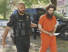Orange Township Police Chief Dan Patel, left, leads Levi Beiler into district court for a hearing Tuesday morning. Beiler is charged with sexually abusing a child.