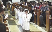 Liza Morris, above, leads a group of angels into the Basilica of Saints Cyril and Methodius for the start of the St. Cyril Academy preschool and kindergarten’s annual Christmas Pageant on Sunday afternoon.