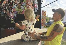 Dalton Sharpe, 34, of Berwick braces his daughter Piper, 3, as she aims a dart at a balloon at the Beach Haven Carnival Wednesday night. The carnival runs 5-9 p.m. every night through Saturday at the Beach Haven carnival grounds. Fireworks are set for 10