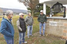 Members of the Elysburg Presbyterian Church stand by its bell this month. The men, from left, Dave Becker, Brent Rhoades, Gary Lerch and Dan Patterson, all played a part in the bell’s restoration and new location in front of the church.