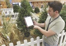 Ben Stolz, digital marketing manager for the Bloomsburg Fair, stands in the Agriculture Building Wednesday while demonstrating how to scan one of the QR codes that are part of the fair’s scavenger hunt.