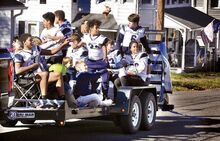 Members of the undefeated Berwick Junior High football team, in photo at right, toss candy and bags of chips as they move down Vine Street in Berwick during a parade in their honor on Saturday. The team won all seven of its regular season games and two more to claim the Wyoming Valley Conference Junior High Championship.